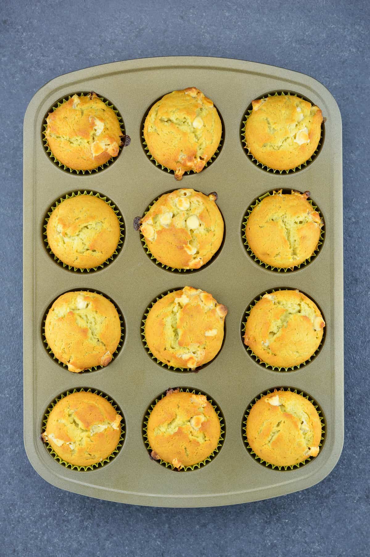 a tray full of 12 banana white chocolate chip muffins