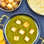 palak paneer in traditional indian serving kadai, with homemade chapatis, and extra pan fried paneer cubes on the side