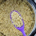 a small quantity of cooked brown rice in a ladle, held above an instant pot full of cooked brown rice