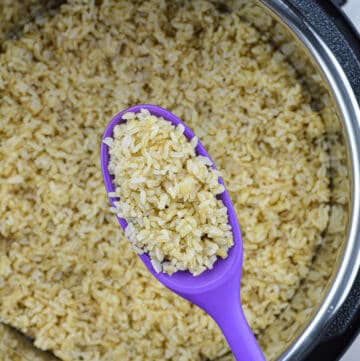 a small quantity of cooked brown rice in a ladle, held above an instant pot full of cooked brown rice