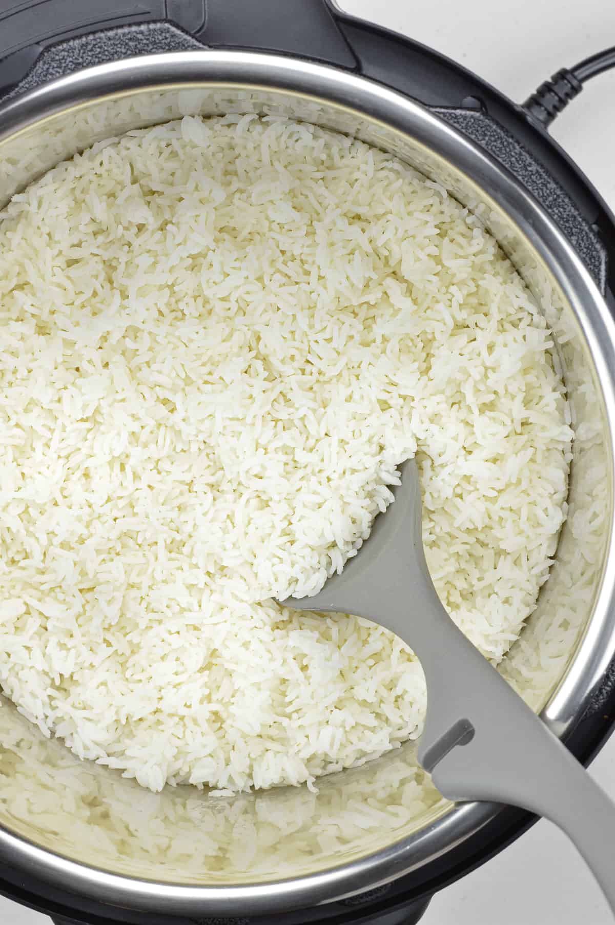 top shot of cooked rice in the instant pot with a ladle in it