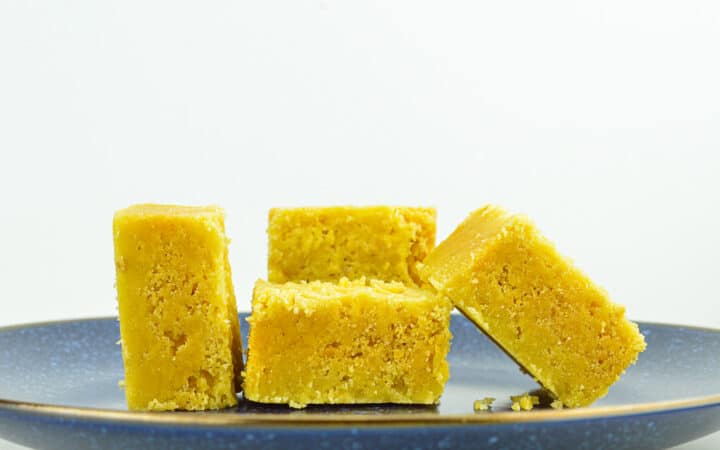 close up of 4 pieces of mysore pak placed on a blue plate