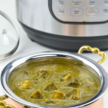 a close up shot of kadai full of palak paneer made in instant pot, with an Instant Pot in the background