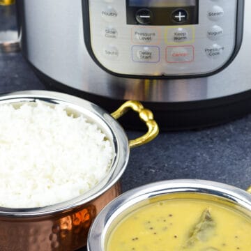 um close-up tiro de um kadai de arroz e um menor kadai de dal com instant pote no plano de fundo