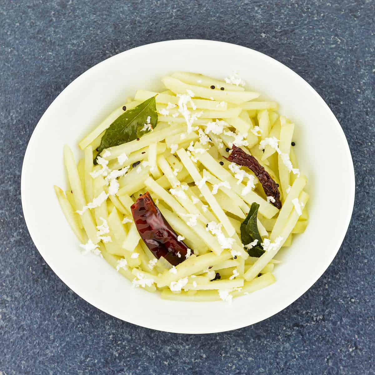 close up top shot of batata upkari in a white serving bowl