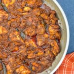 top shot of chicken ghee roast in a pan, with a kitchen towel on the side