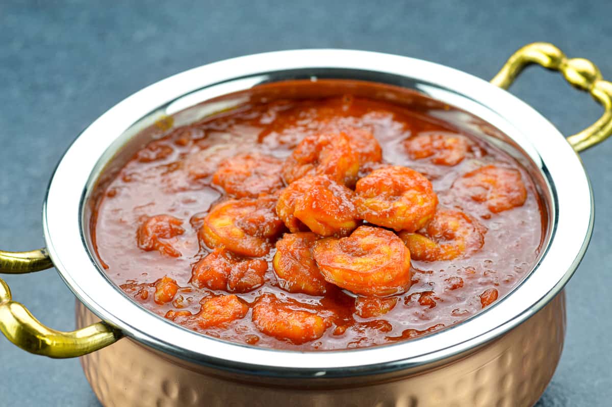 a close up shot of a serving kadai full of mangalorean prawns curry