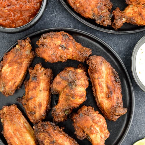 platters of tandoori chicken wings served with dipping sauces on the side.