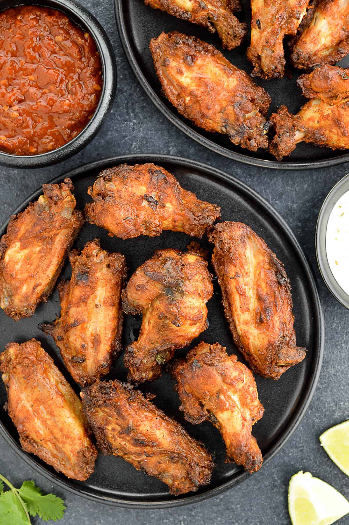 platters of tandoori chicken wings served with dipping sauces on the side.