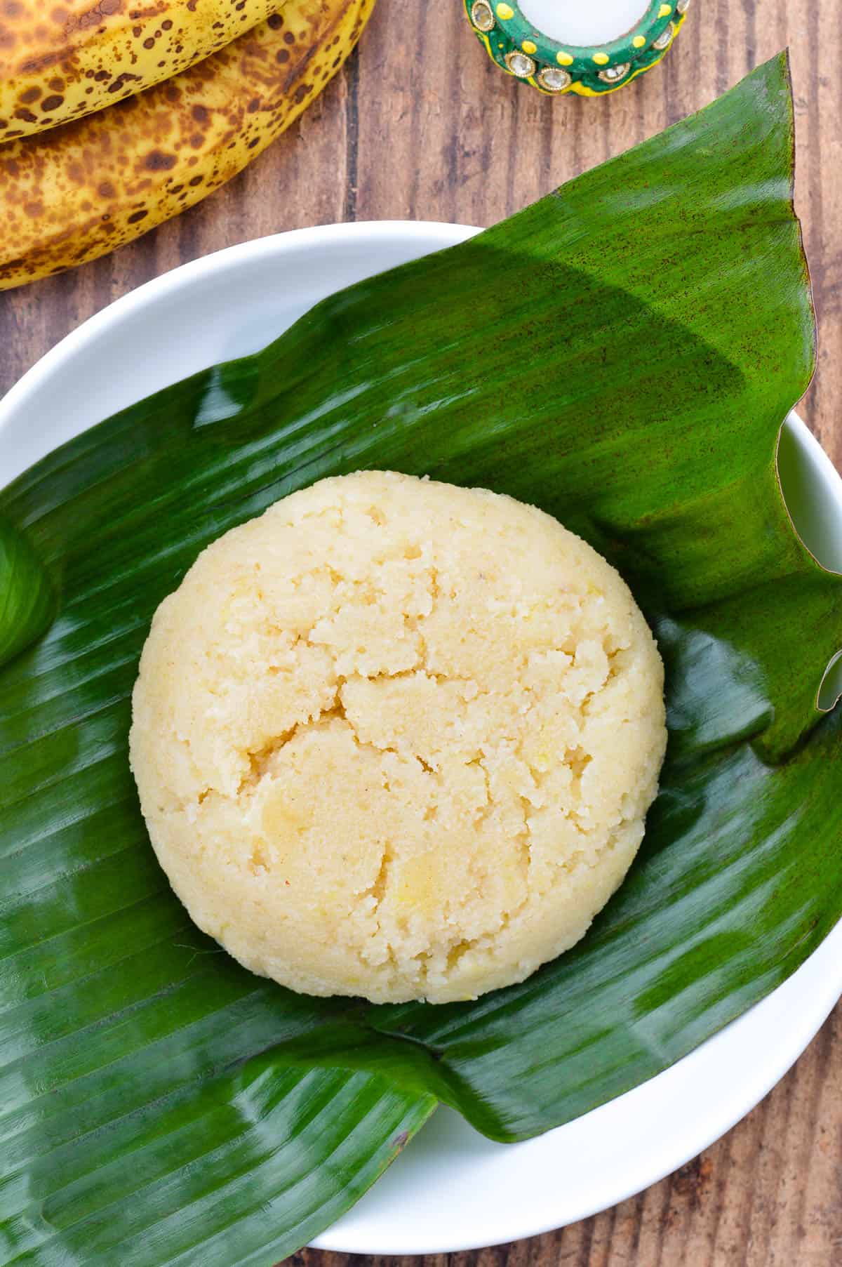 a big mound of sapaath / banana sheera placed over a banana leaf in a large wide bowl