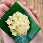 a single serving of sapaath / satyanarayan pooja prasad, on a small piece of banana leaf, held in the palm of a hand