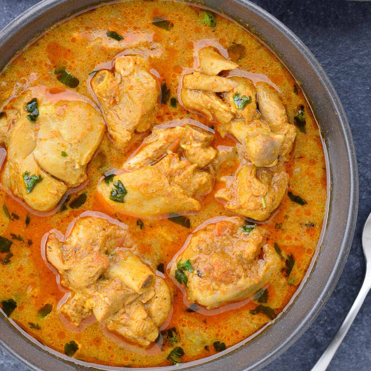 close up shot of a bowl full of indian chicken curry.