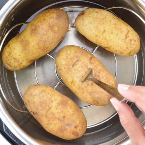 a close up of fork-tender boiled potatoes placed on a trivet inside the instant pot.