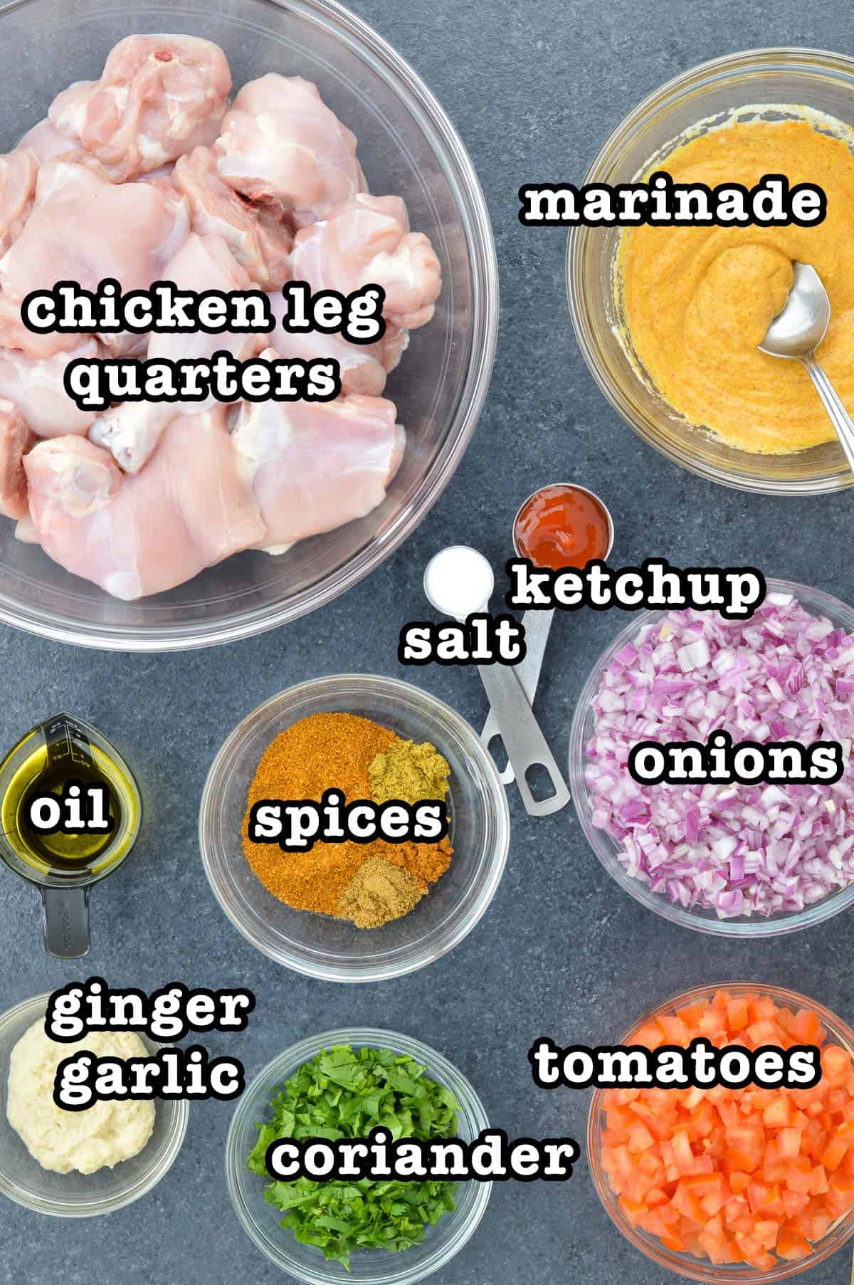 top shot of all the ingredients required to make indian chicken curry, shared along with ingredient labels.