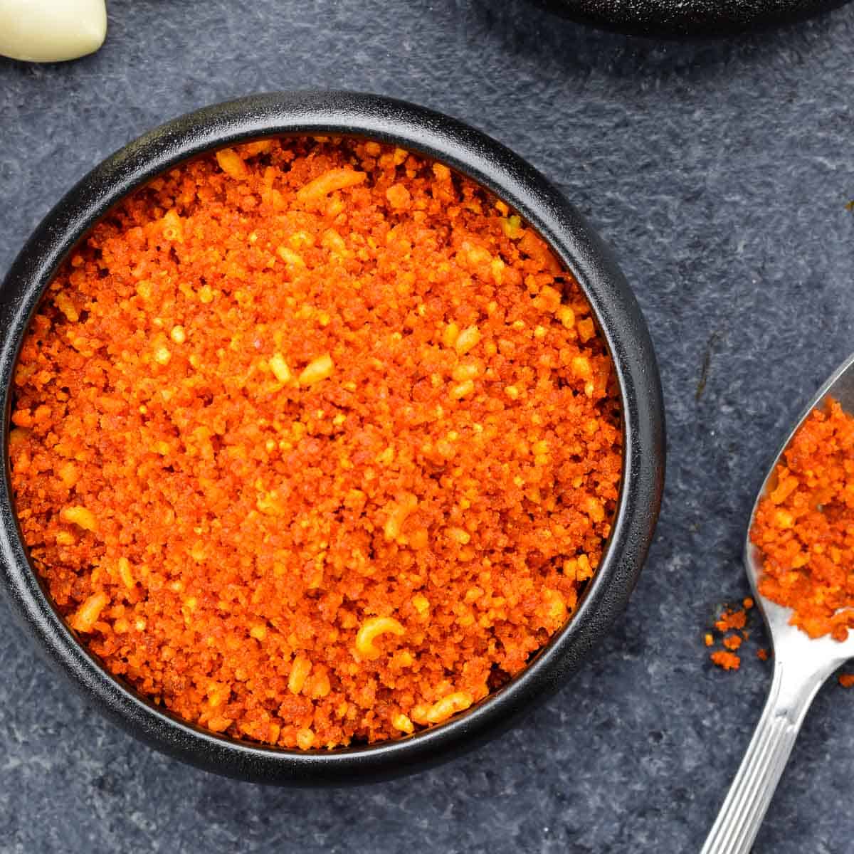 close up shot of a small bowl full of dry garlic chutney for vada pav.