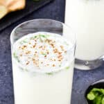 close up shot of a glass full of mattha taak, with another glass of mattha in the background.