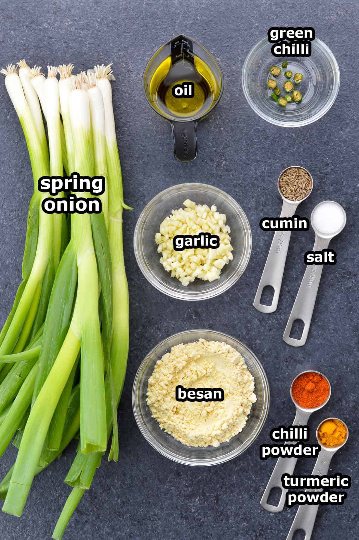 top shot of all the ingredients required to make spring onion sabzi, shared along with ingredient labels.