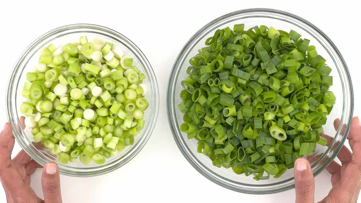 a bowl of chopped spring onion whites and a bowl of chopped spring onion greens placed side by side.