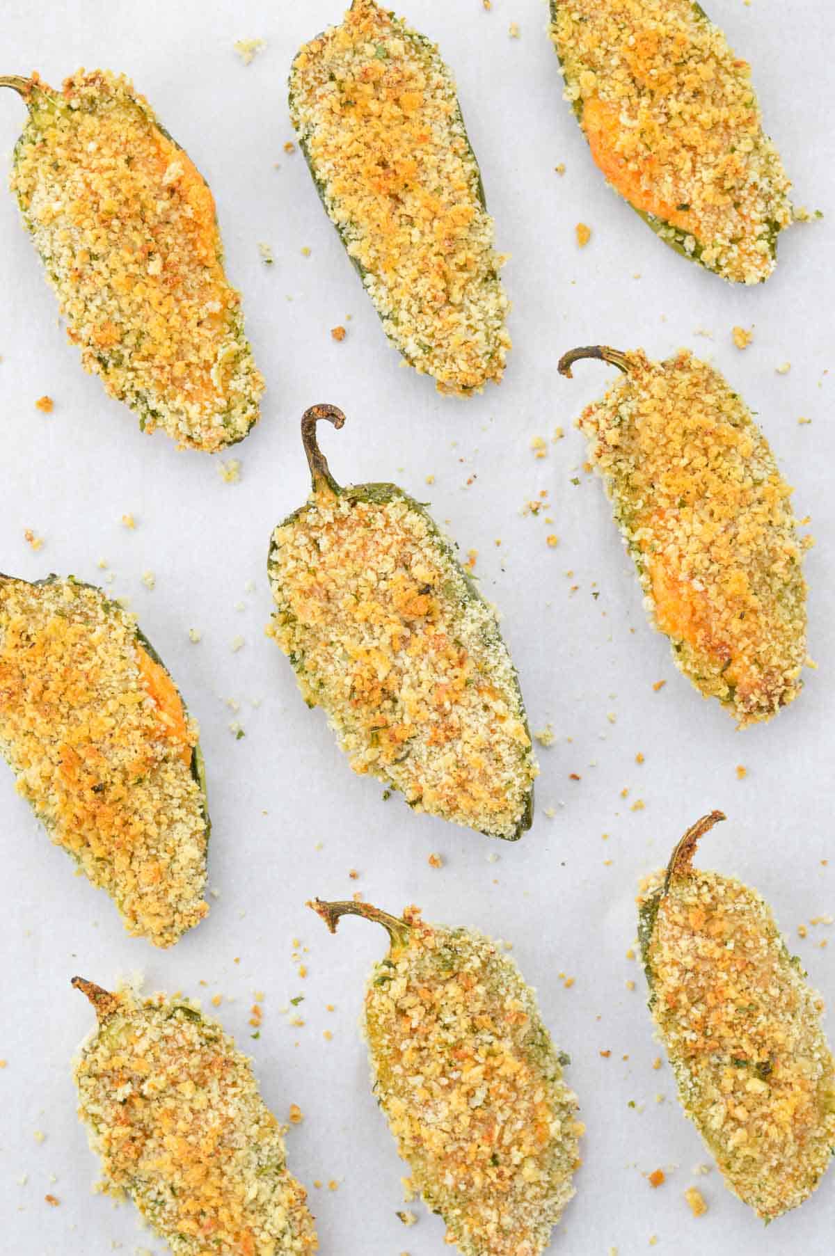air fryer jalapeno poppers laid out on white parchment paper.